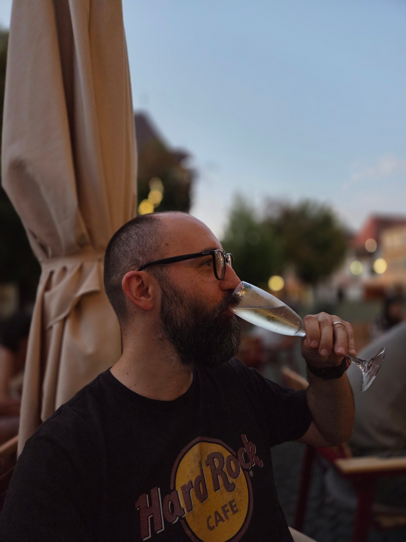 Eu, pe o terasă la apus, cu un pahar de spumant în mână.